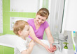 © Andrey Kuzmin - Happy mother and kid washing hands with soap together in bathroo