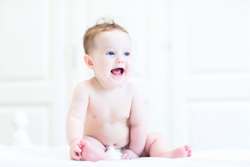 Wall Mural - Funny baby sitting on a white nursery