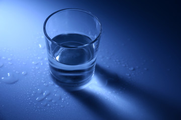 Water in  glass, on dark blue background