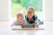 teenager boy with toddler sister playing on tablet pc 