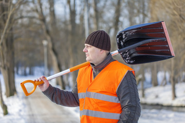 Man with a snow shovel on the sidewalk