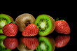 ripe kiwi and strawberry on a black background with mirror refle
