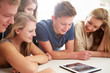 © Monkey Business - Group Of Teenagers Gathered Around Digital Tablet Together