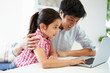 © Monkey Business - Asian Father Helping Daughter To Use Laptop At Home