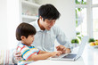 © Monkey Business - Asian Father Helping Son To Use Laptop At Home