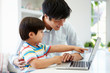 © Monkey Business - Asian Father Helping Son To Use Laptop At Home