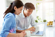 © Monkey Business - Asian Couple Looking at Laptop In Kitchen