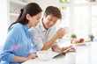 © Monkey Business - Asian Couple Looking At Digital Tablet Over Breakfast