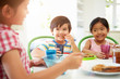 © Monkey Business - Three Asian Children Having Breakfast Together In Kitchen