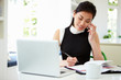 © Monkey Business - Asian Businesswoman Working From Home Using Mobile Phone