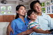© Monkey Business - Asian Family Sitting On Sofa Watching TV Together