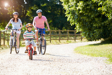 Asian Family On Cycle Ride In Countryside