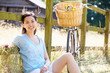 © Monkey Business - Asian Woman Resting By Fence With Old Fashioned Cycle