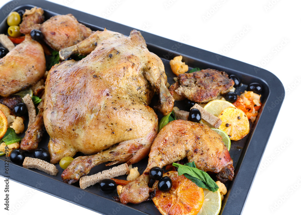 Whole roasted chicken with vegetables on tray, isolated on