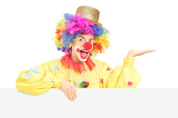 Poster - Smiling male clown standing behind blank panel