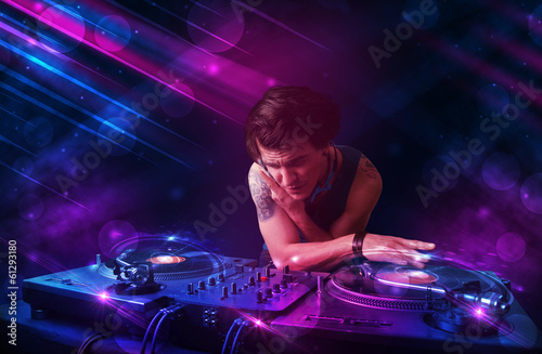 Plakat na papierze fotorealistycznym Młody dj grający na gramofonach z kolorowymi efektami świetlnymi