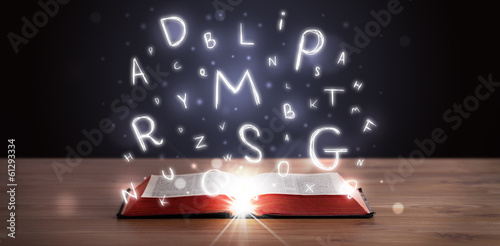Board z aluminiowym obramowaniem Otwarta książka z świecącymi literami wylatującymi