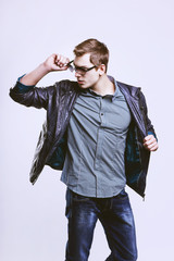 Wall Mural - Young handsome macho man in sunglasses with open leather jacket