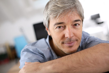 Wall Mural - Smiiling mature man relaxing in office chair