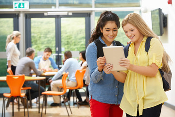 Two Female Teenage Students In Classroom With Digital Tablet