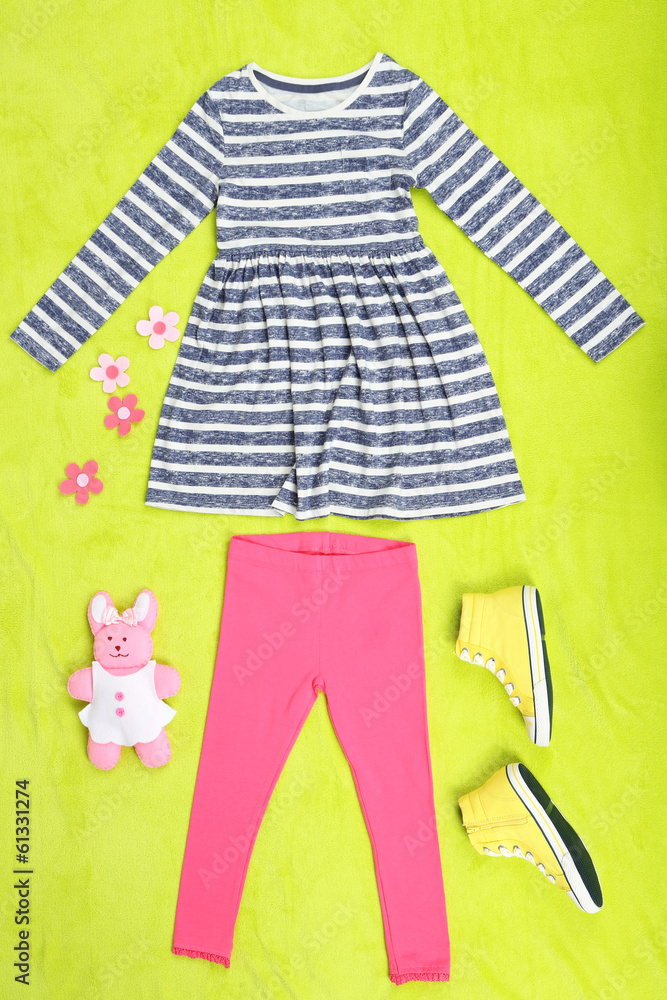 Beautiful clothes for little girl on green background