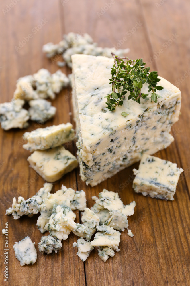 Tasty blue cheese with thyme, on wooden table