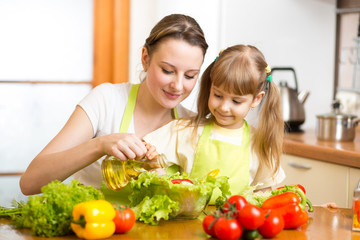 Happy womancooking with child at kitchen