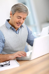 Wall Mural - Senior businessman in office working on laptop