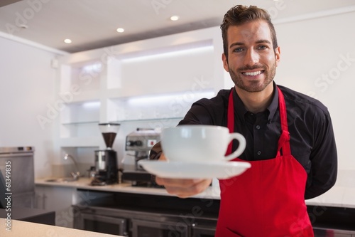Fotografie, Obraz Happy barista offering cup of coffee to camera