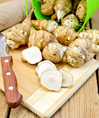 Poster - Jerusalem artichokes cut with knife and bucket on board