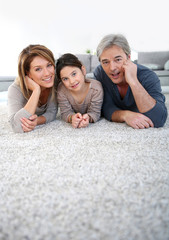 Wall Mural - Middle-aged couple with little girl laying on carpet