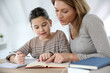 © goodluz - Mom helping kid with homework