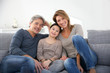 © goodluz - Happy family of three relaxing in sofa