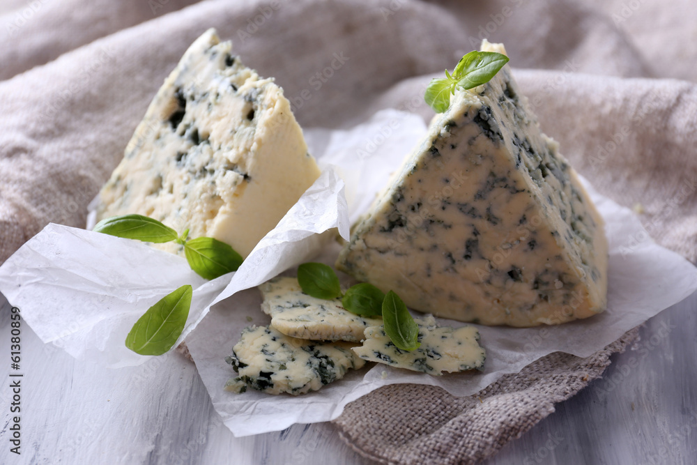 Tasty blue cheese with basil on paper