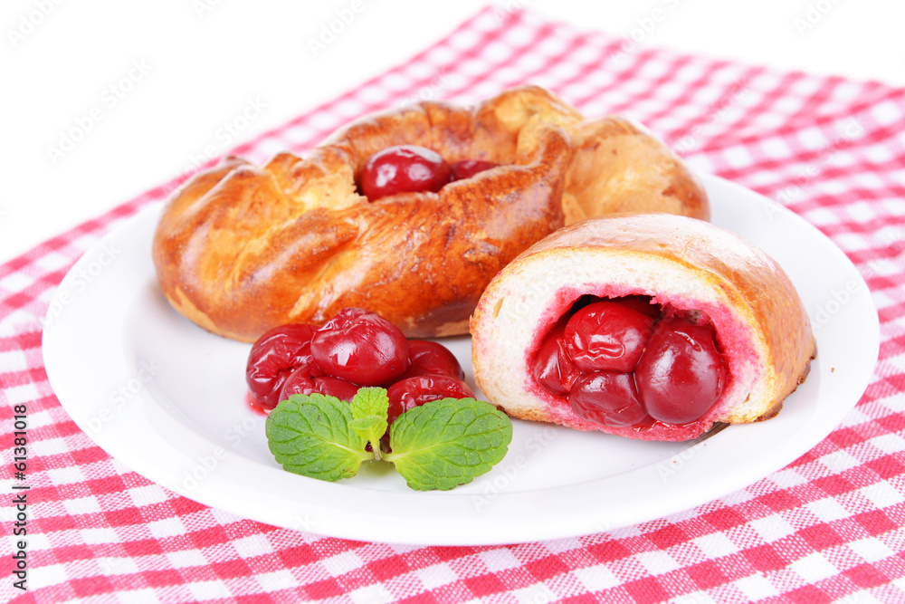 Fresh baked pasties with cherry on plate on table close-up