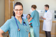© Tyler Olson - Nurse Smiling Against Patient And Medical Team In Hospital