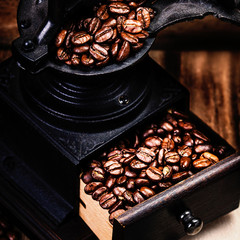 Poster - Vintage manual coffee grinder with coffee beans on wooden brown