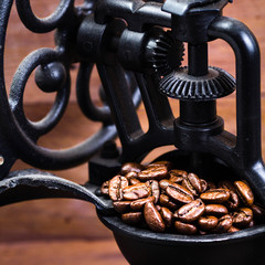 Poster - Vintage manual coffee grinder with coffee beans on wooden brown