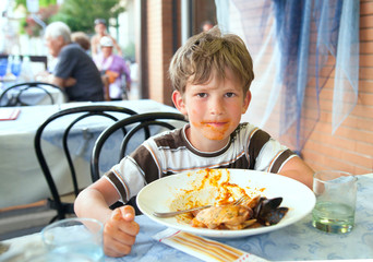 The schoolboy with plate of empty shells and mussels