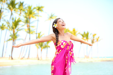 Happy woman praising freedom, palm beach in sarong