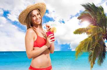 Wall Mural - Woman drinking a cocktail on the beach