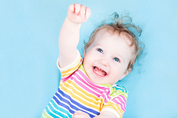 funny happy baby girl on blue background