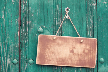 Wooden signboard with rope hanging on planks background