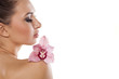 © vladimirfloyd - Side view of a girl posing with orchid on white background