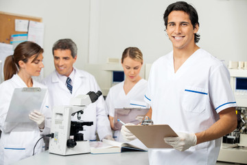 Canvas Print - Male Scientist Holding Clipboard In Lab