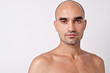 Bald Caucasian handsome man with topless shoulders.
