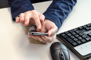 mobile in hands, mouse and keyboard