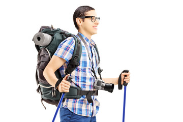 Canvas Print - Young male tourist walking with hiking poles