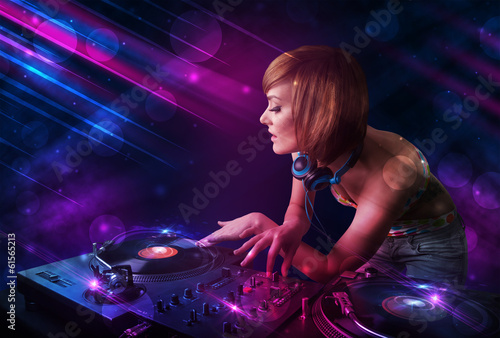 Plakat na papierze fotorealistycznym Młody dj grający na gramofonach z kolorowymi efektami świetlnymi