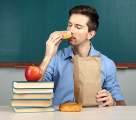 Wall Mural - Young teacher sitting in school classroom